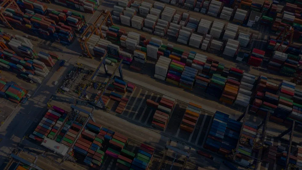 Aerial view of thousands of shipping containers stacked in a terminal yard.